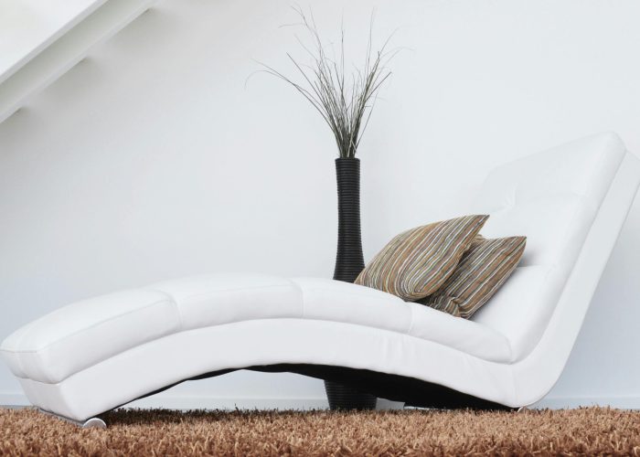 pexels-photo-276534-276534 Elegant white lounge chair with cushions on plush carpet, perfect for relaxation.